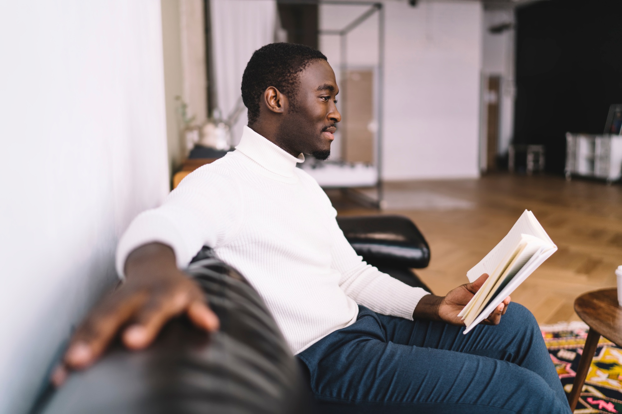 Thoughtful man on sofa with book
